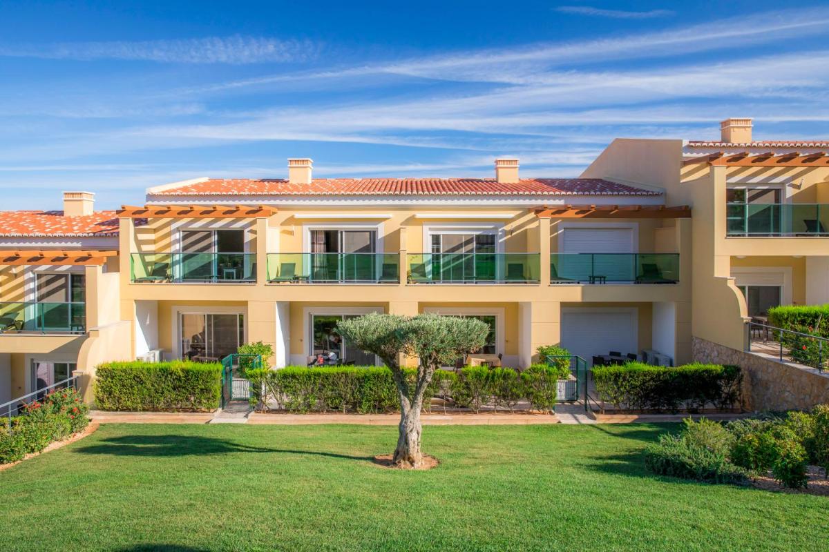 uma grande casa amarela com uma árvore no quintal em Boavista Golf & Spa - Bela Colina Holidays em Lagos