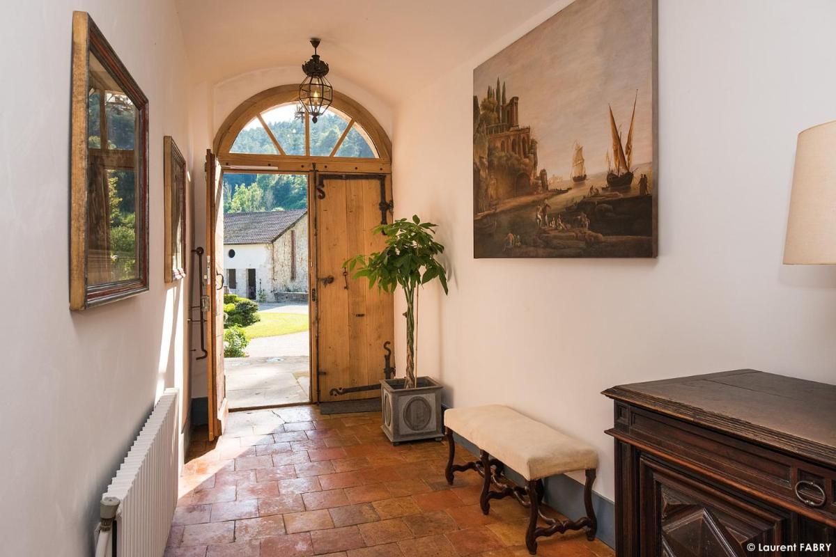 un couloir avec une table, une chaise et une porte dans l'établissement Château de Maillat, à Maillat