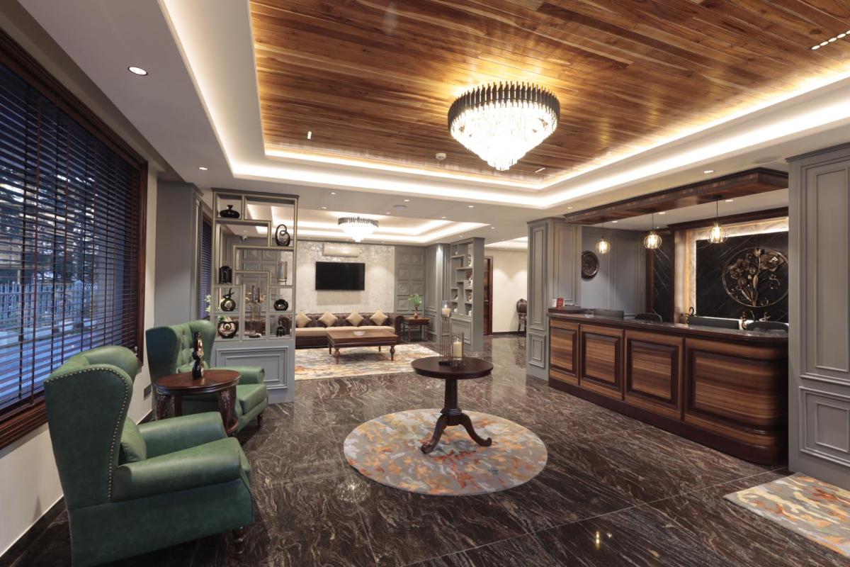 a lobby with a couch and a table and chairs at WelcomHeritage Elysium Resort & Spa in Shimla