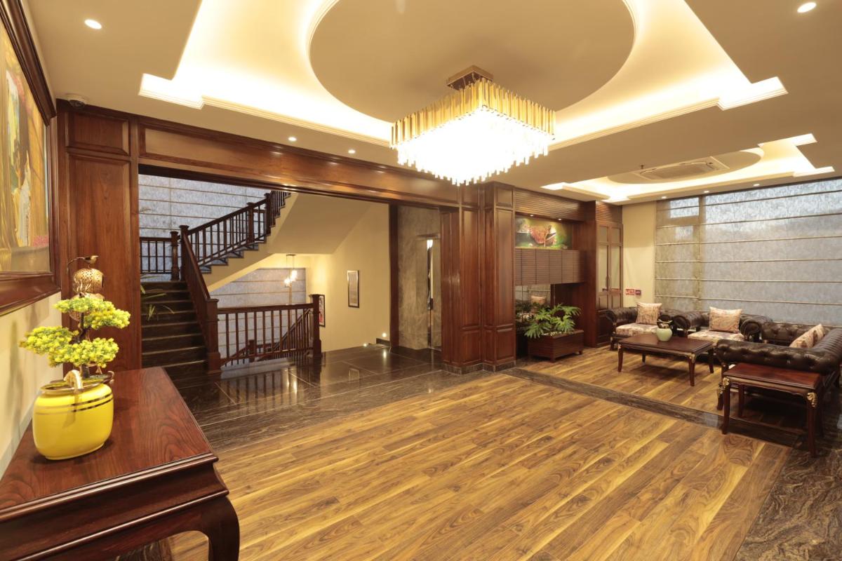 a living room with a couch and a chandelier at WelcomHeritage Elysium Resort & Spa in Shimla
