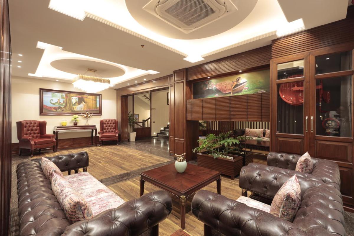 a lobby with a leather couch and a table at WelcomHeritage Elysium Resort & Spa in Shimla