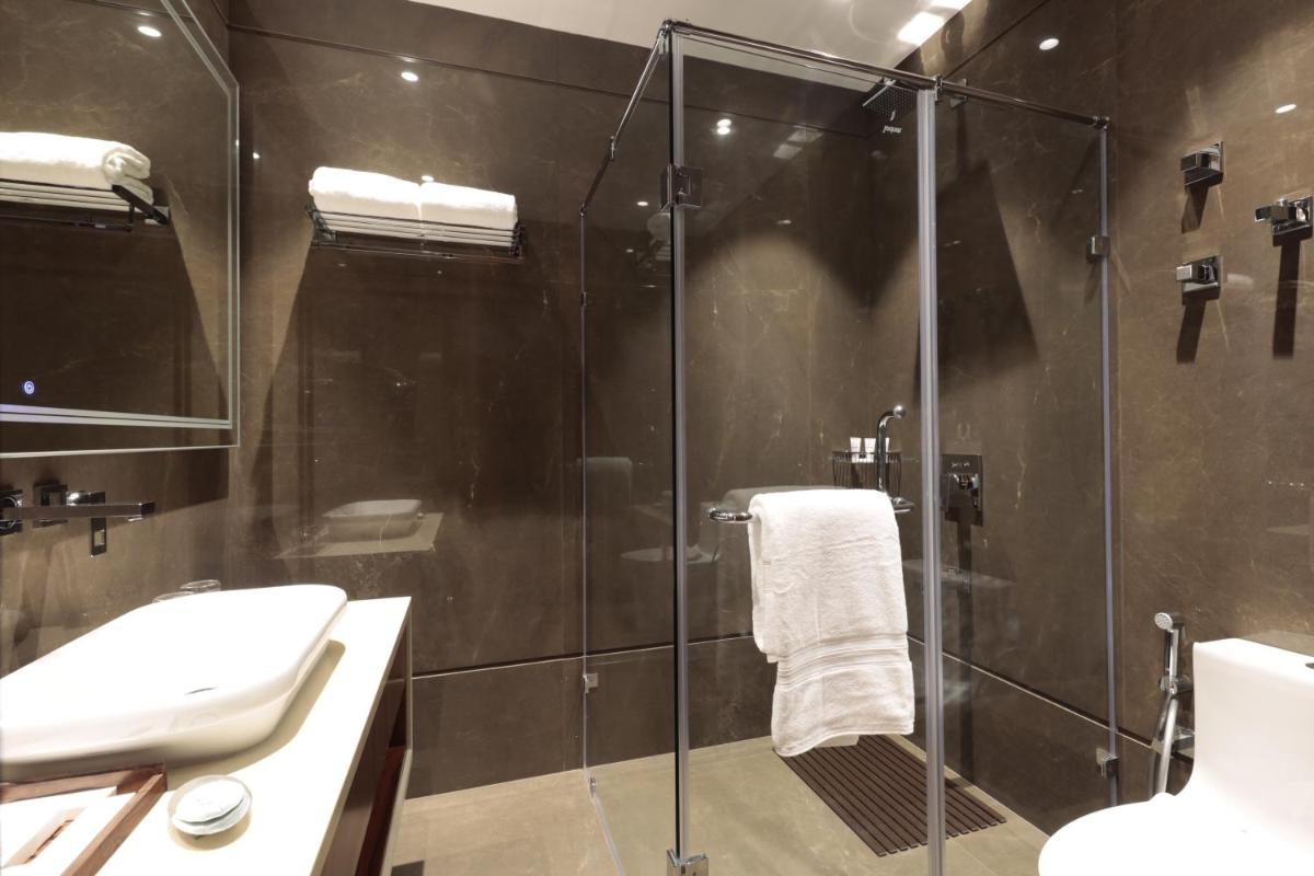 a bathroom with a glass shower and a sink at WelcomHeritage Elysium Resort & Spa in Shimla