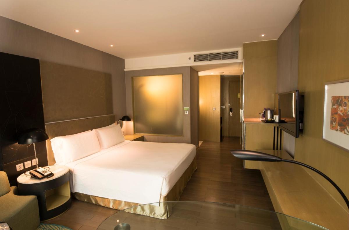 a hotel room with a white bed and a couch at Holiday Inn New Delhi Aerocity by IHG in New Delhi