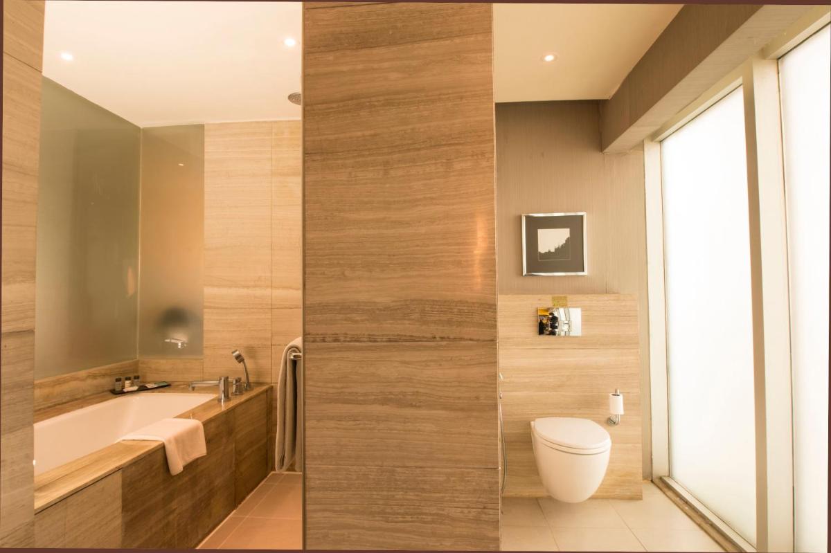 a bathroom with a tub and a toilet and a sink at Holiday Inn New Delhi Aerocity by IHG in New Delhi