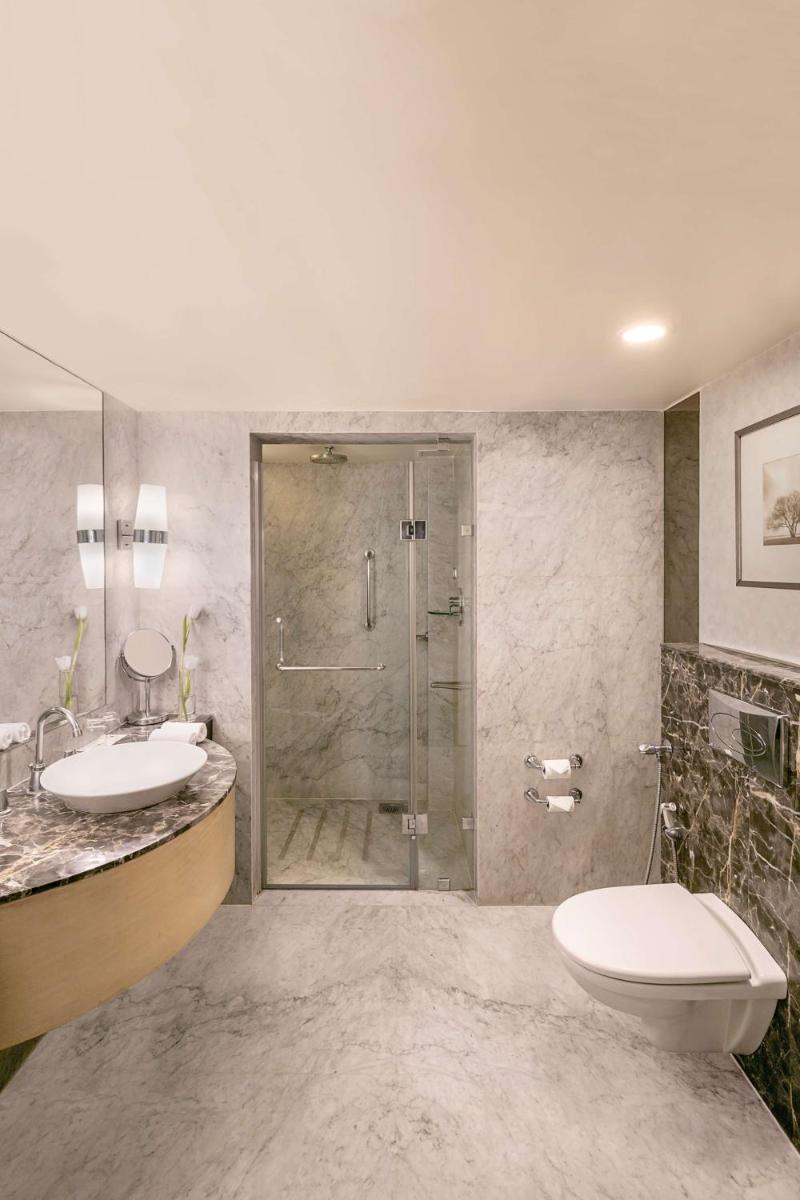 a bathroom with a shower and a toilet and a sink at Radisson Blu Hotel Ahmedabad in Ahmedabad