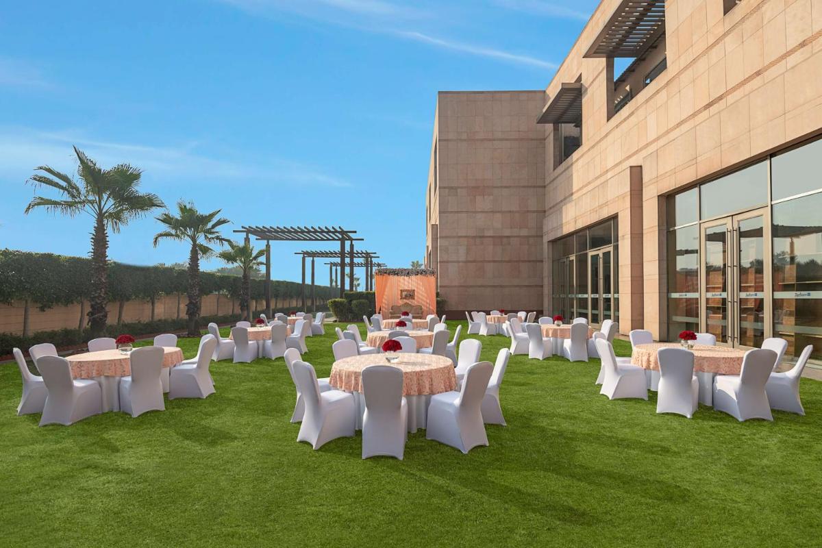 a group of tables and chairs in front of a building at Radisson Blu Hotel Amritsar in Amritsar