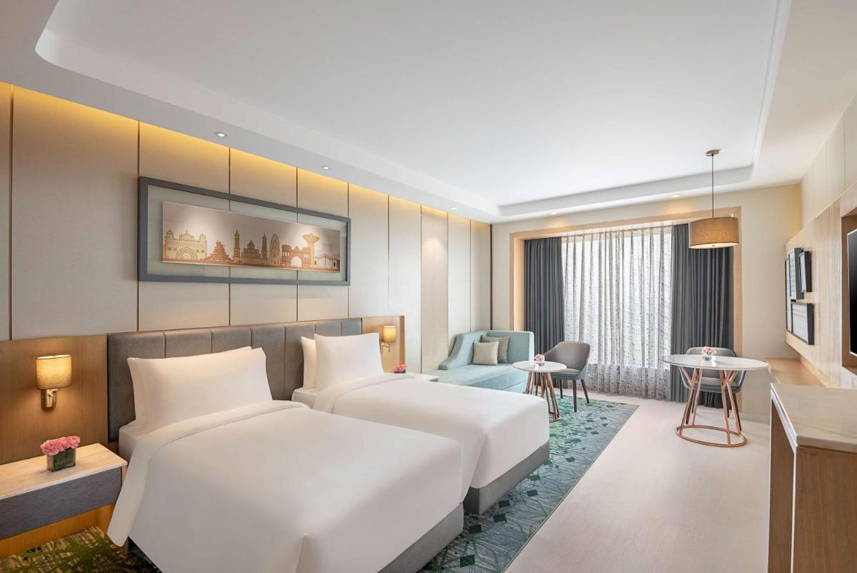 a hotel room with two beds and a table at Radisson Blu Hotel Amritsar in Amritsar