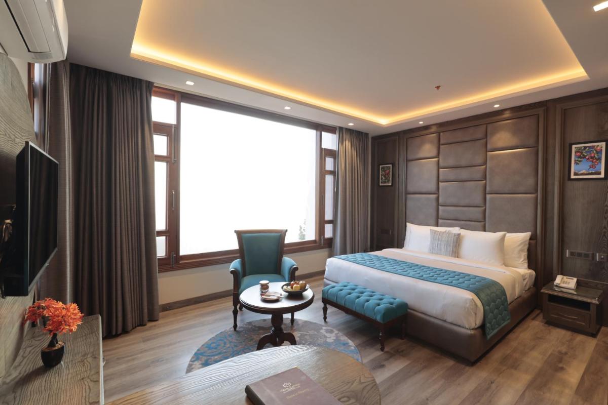 a hotel room with a bed and a table at WelcomHeritage Elysium Resort & Spa in Shimla