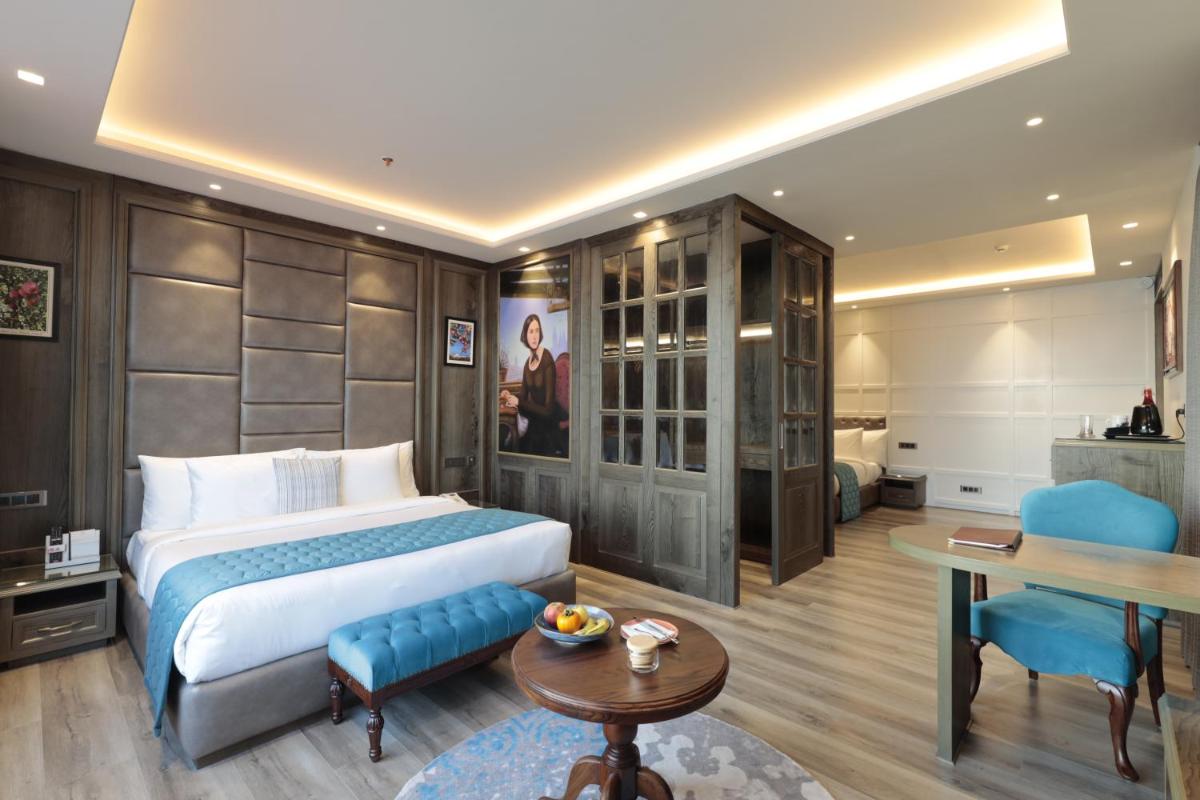 a hotel room with a bed and a table at WelcomHeritage Elysium Resort & Spa in Shimla