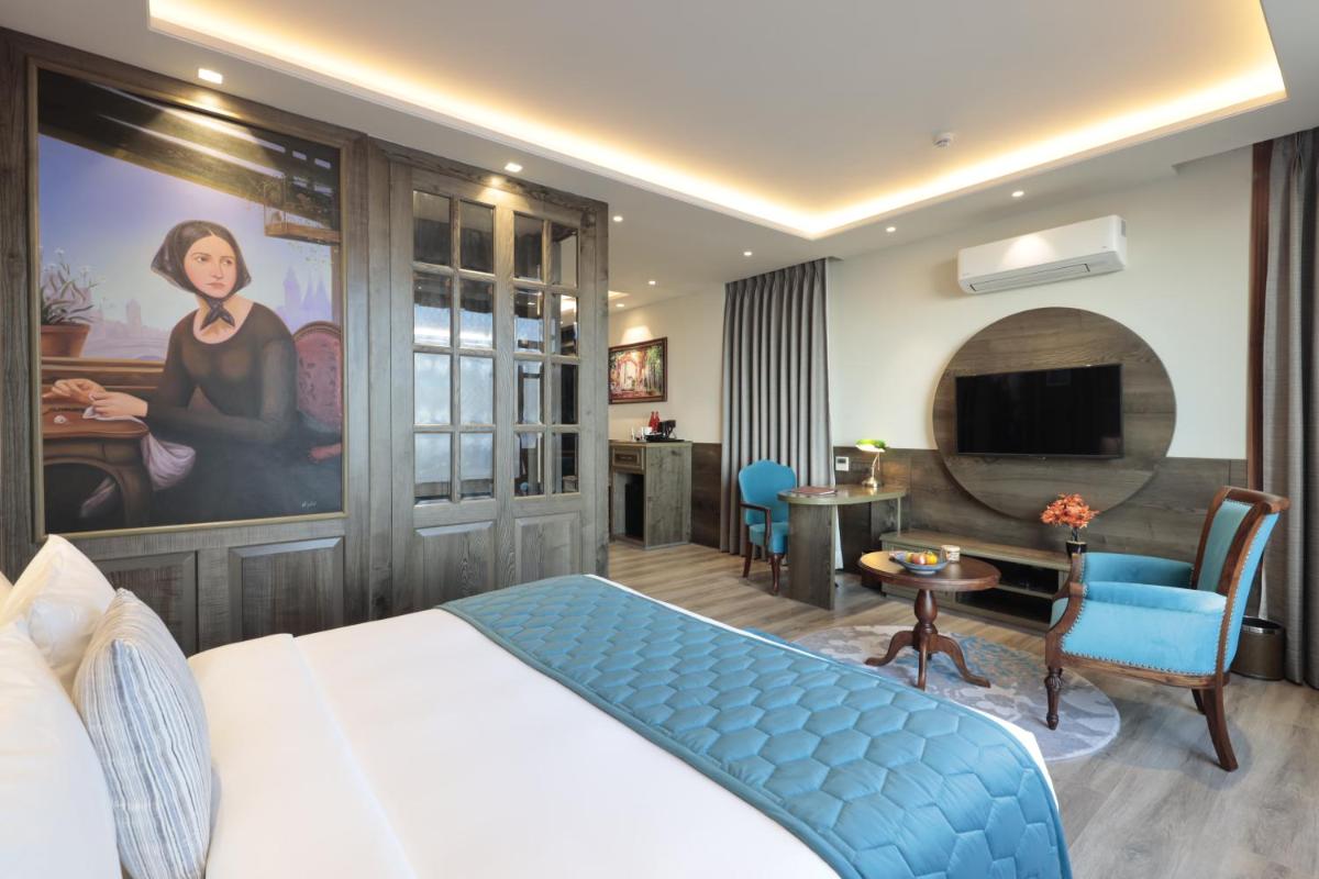 a bedroom with a king sized bed and a living room at WelcomHeritage Elysium Resort & Spa in Shimla