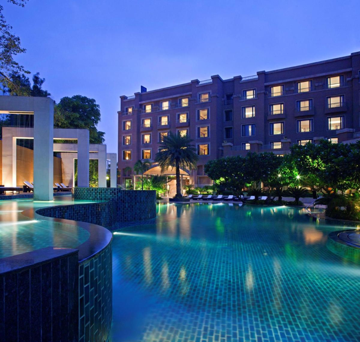 a swimming pool in front of a building at night at Radisson Blu Plaza Delhi Airport in New Delhi a swimming pool in front of a building at night at Radisson Blu Plaza Delhi Airport in New Delhi
