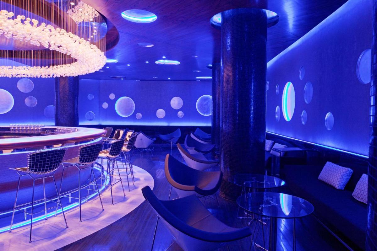 a bar with chairs and tables in a room at Radisson Blu Plaza Delhi Airport in New Delhi a bar with chairs and tables in a room at Radisson Blu Plaza Delhi Airport in New Delhi