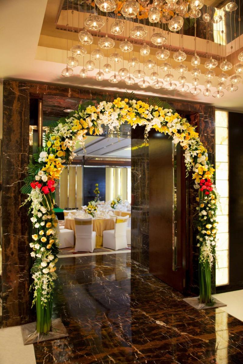 an entrance to a restaurant with an arch with flowers at Radisson Blu Plaza Delhi Airport in New Delhi an entrance to a restaurant with an arch with flowers at Radisson Blu Plaza Delhi Airport in New Delhi
