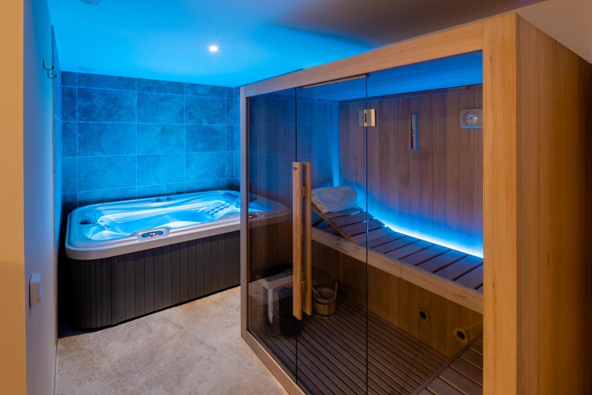 La salle de bains est pourvue d'une baignoire avec des lumières bleues. dans l'établissement Hostellerie du Château des Fines Roches, à Châteauneuf-du-Pape