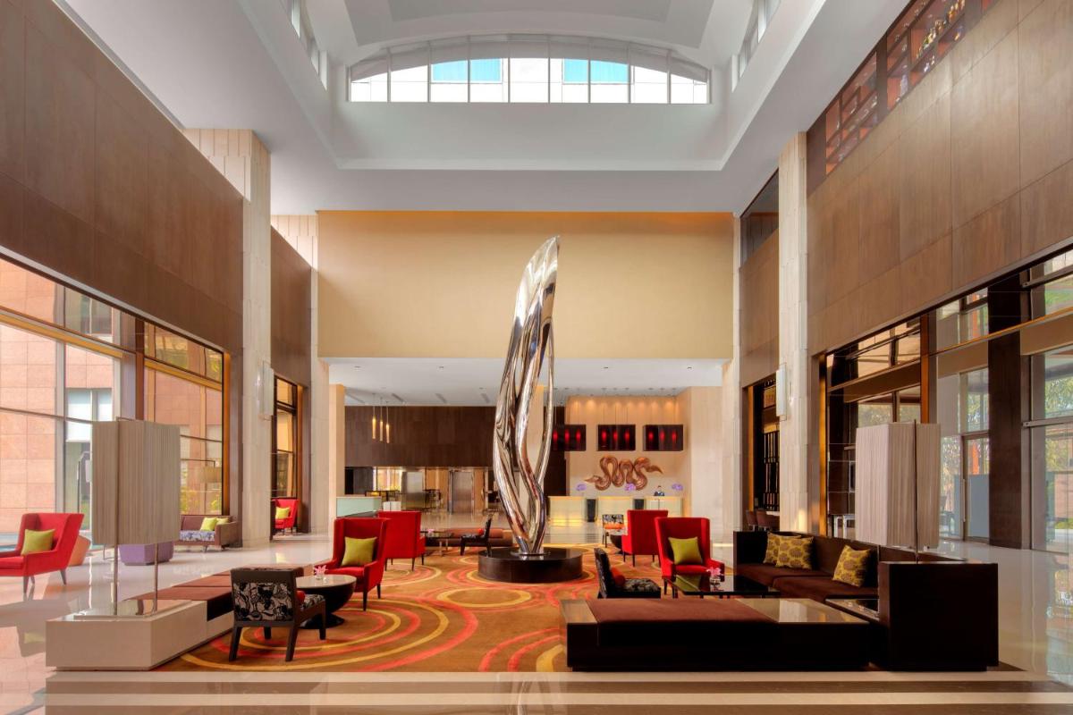a lobby with a couch and chairs and a fountain at Radisson Blu Hotel Guwahati in Guwahati