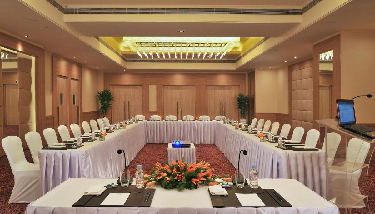 a conference room with a long table with white tables and chairs at Radisson Hyderabad Hitec City in Hyderabad