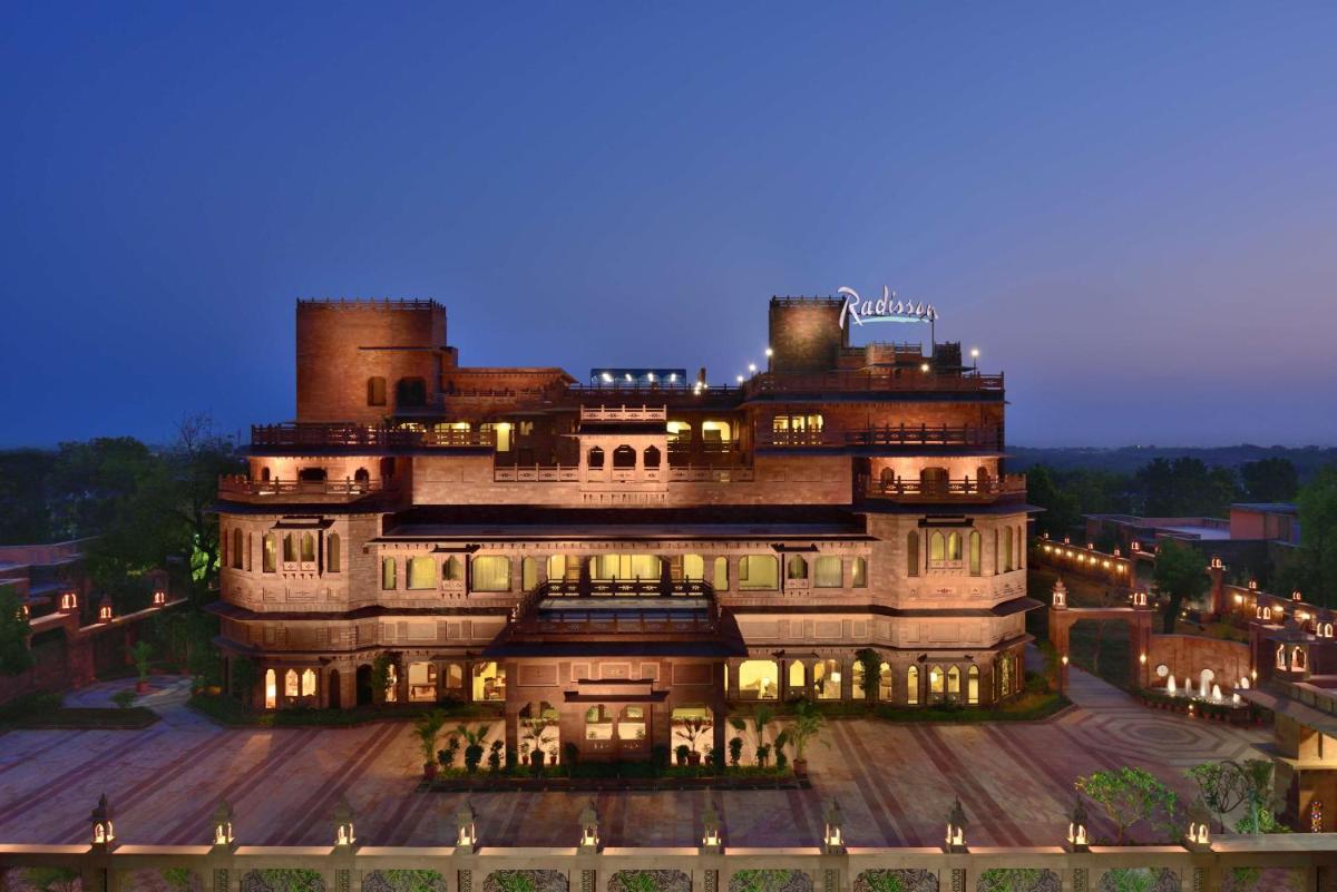 a large building with lights on it at night at Radisson Jodhpur in Jodhpur
