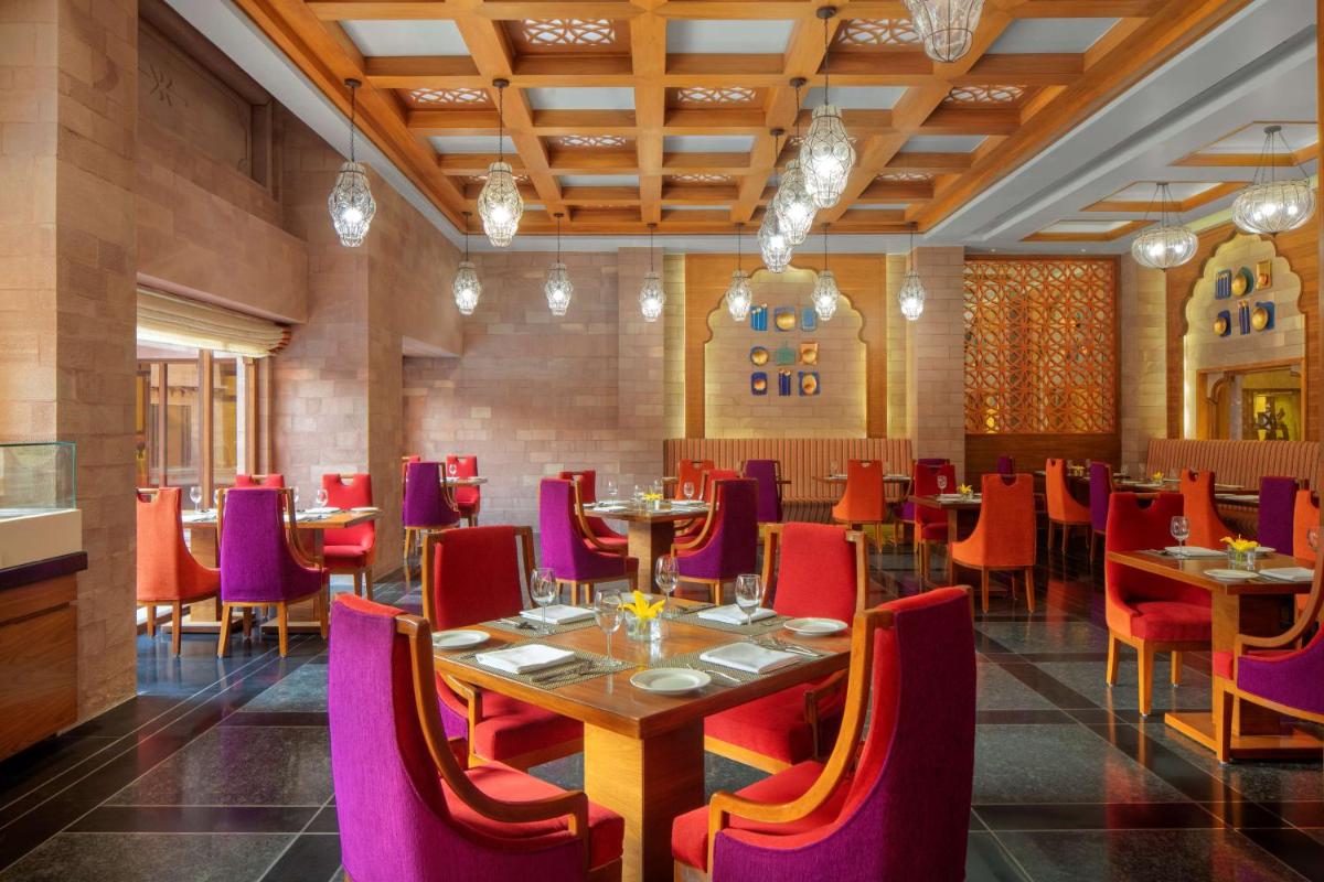 a dining room with tables and purple chairs at Radisson Jodhpur in Jodhpur