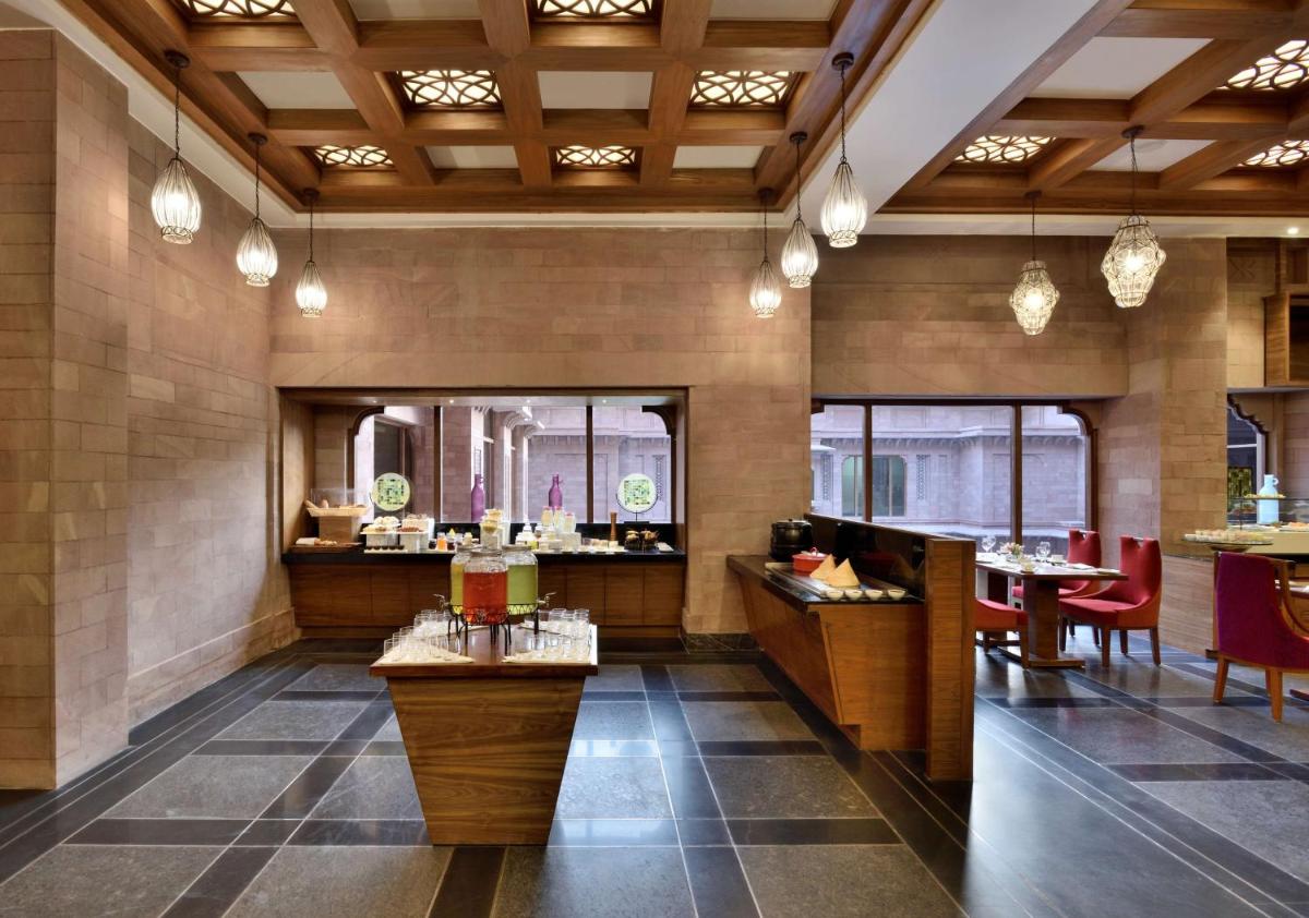 a lobby of a restaurant with tables and chairs at Radisson Jodhpur in Jodhpur