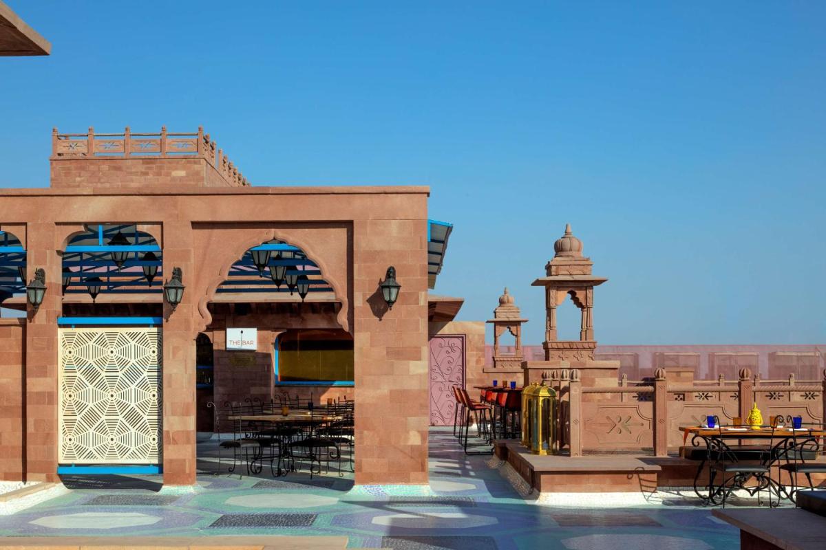 a patio with tables and chairs on a building at Radisson Jodhpur in Jodhpur