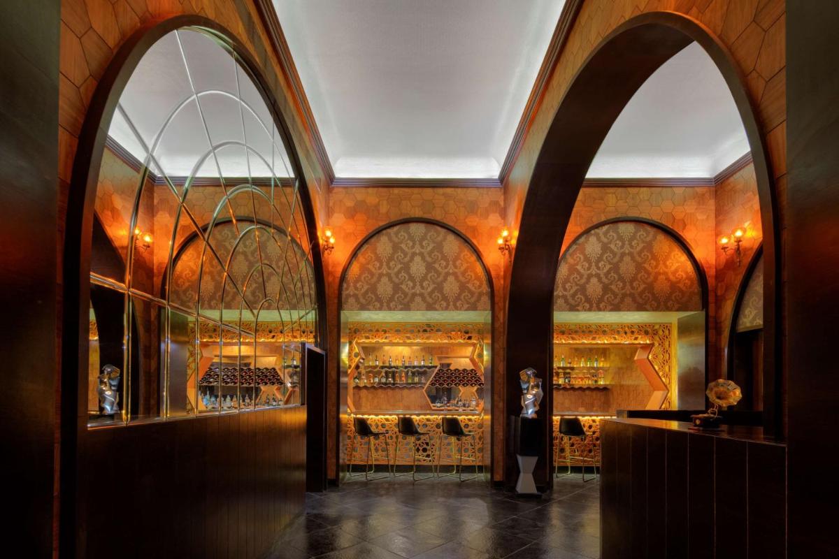 a room with three arched windows in a building at Radisson Jodhpur in Jodhpur