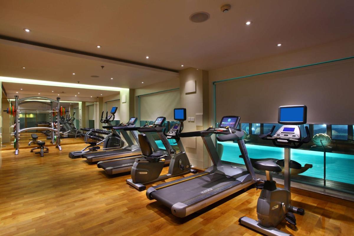 a gym with a row of treadmills and machines at Park Plaza Shahdara in New Delhi a gym with a row of treadmills and machines at Park Plaza Shahdara in New Delhi