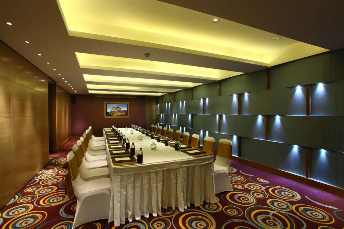 a long dining room with a long table with chairs at Park Plaza Shahdara in New Delhi a long dining room with a long table with chairs at Park Plaza Shahdara in New Delhi