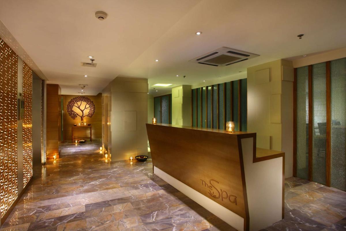 a lobby of a hotel with a staircase and a table at Park Plaza Shahdara in New Delhi a lobby of a hotel with a staircase and a table at Park Plaza Shahdara in New Delhi
