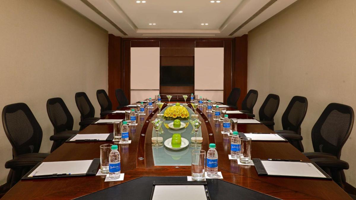 a long meeting room with a long table with chairs at Radisson Blu Jaipur in Jaipur
