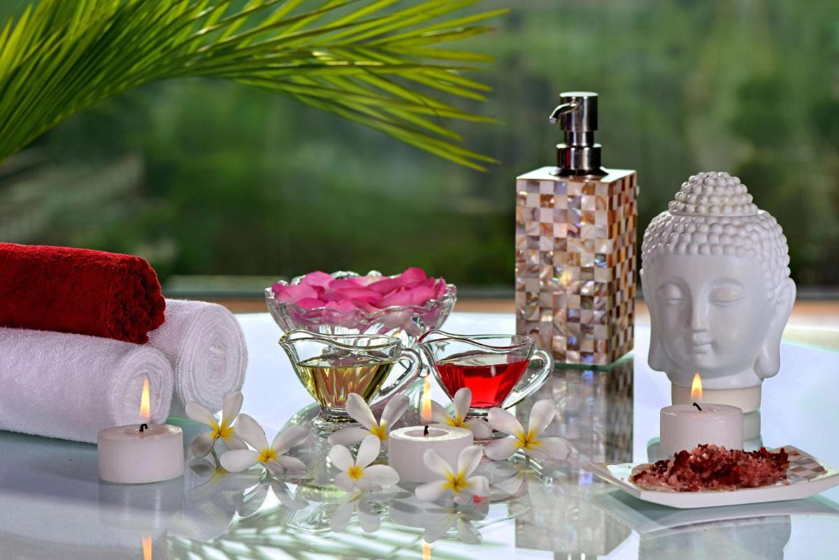 a table with a candle and a bottle of wine and flowers at Radisson Blu Jaipur in Jaipur