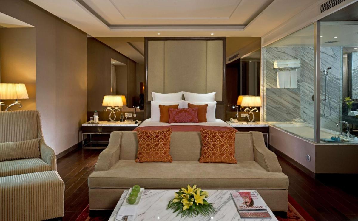 a hotel room with a bed and a couch at Radisson Blu Jaipur in Jaipur