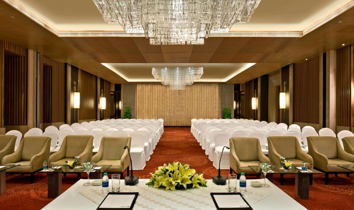 a conference room with a rows of tables and chairs at Radisson Blu Jaipur in Jaipur