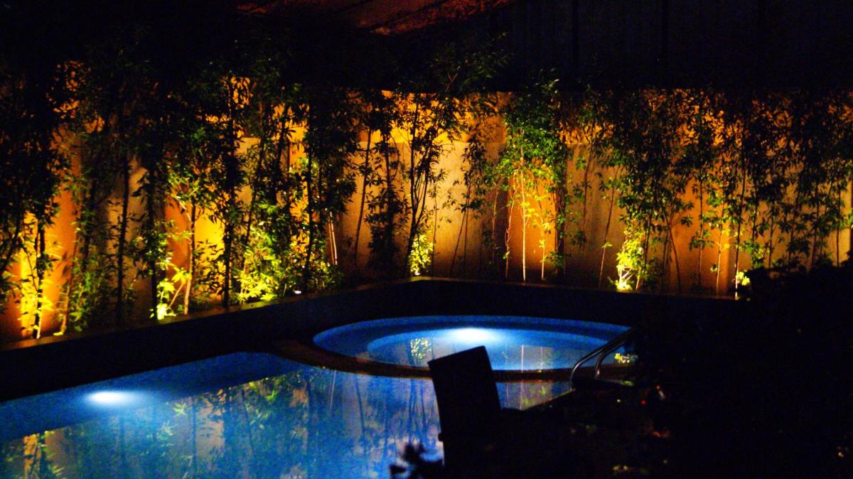 a swimming pool in a backyard at night at Radisson Blu Hotel Ahmedabad in Ahmedabad