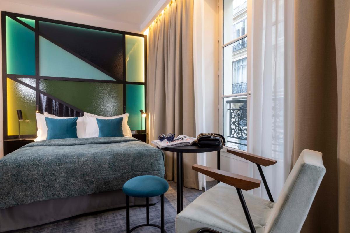 une chambre avec un lit, une table et une chaise dans l'établissement Le 12 Hôtel, à Paris