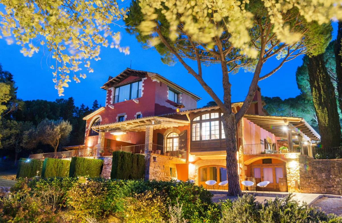 una gran casa roja con un árbol delante en Mas Ses Vinyes - Adults Only, en Begur