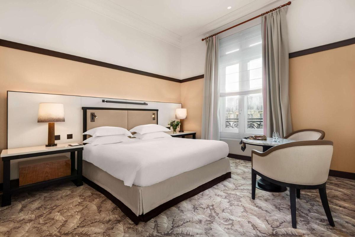 une chambre avec un grand lit blanc et un bureau dans l'établissement Hyatt Paris Madeleine, à Paris 37 autres photos