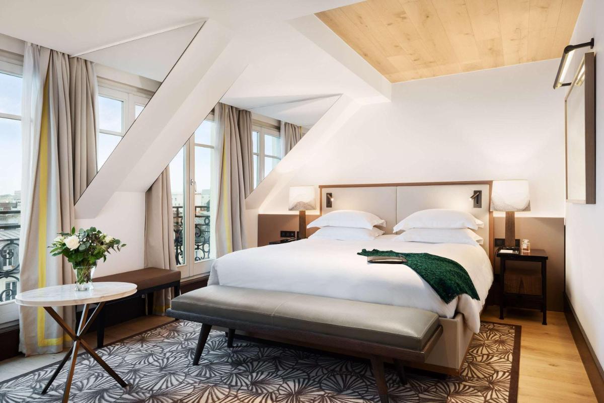 une chambre avec un grand lit blanc et des fenêtres dans l'établissement Hyatt Paris Madeleine, à Paris