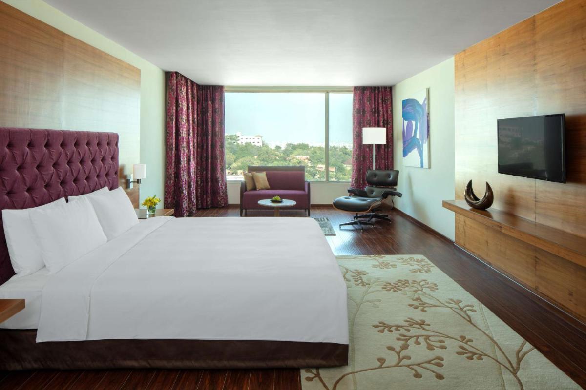 a hotel room with a large bed and a large window at Radisson Blu Plaza Hotel Hyderabad Banjara Hills in Hyderabad a hotel room with a large bed and a large window at Radisson Blu Plaza Hotel Hyderabad Banjara Hills in Hyderabad