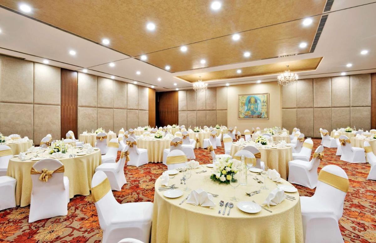 a banquet hall with white tables and white chairs at Radisson Blu Plaza Hotel Hyderabad Banjara Hills in Hyderabad a banquet hall with white tables and white chairs at Radisson Blu Plaza Hotel Hyderabad Banjara Hills in Hyderabad