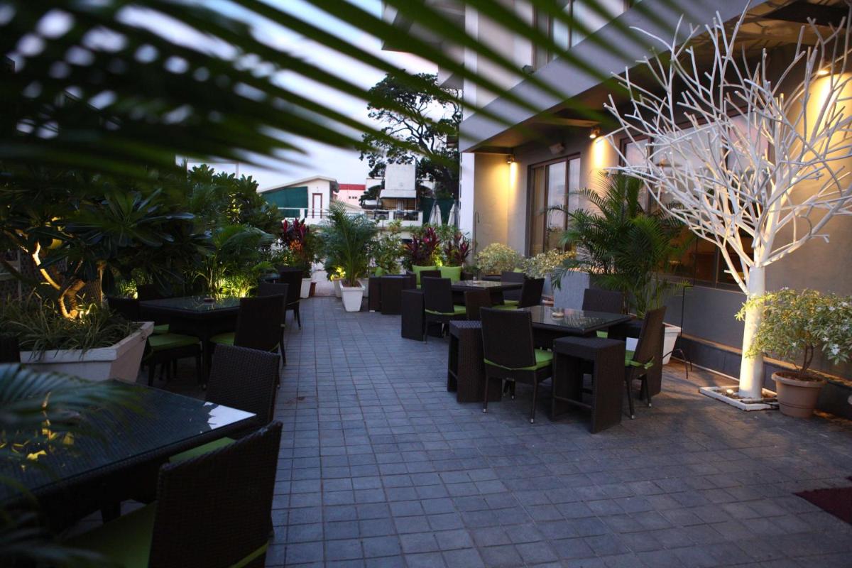 an outdoor patio with tables and chairs and plants at Radisson Blu Plaza Hotel Hyderabad Banjara Hills in Hyderabad an outdoor patio with tables and chairs and plants at Radisson Blu Plaza Hotel Hyderabad Banjara Hills in Hyderabad