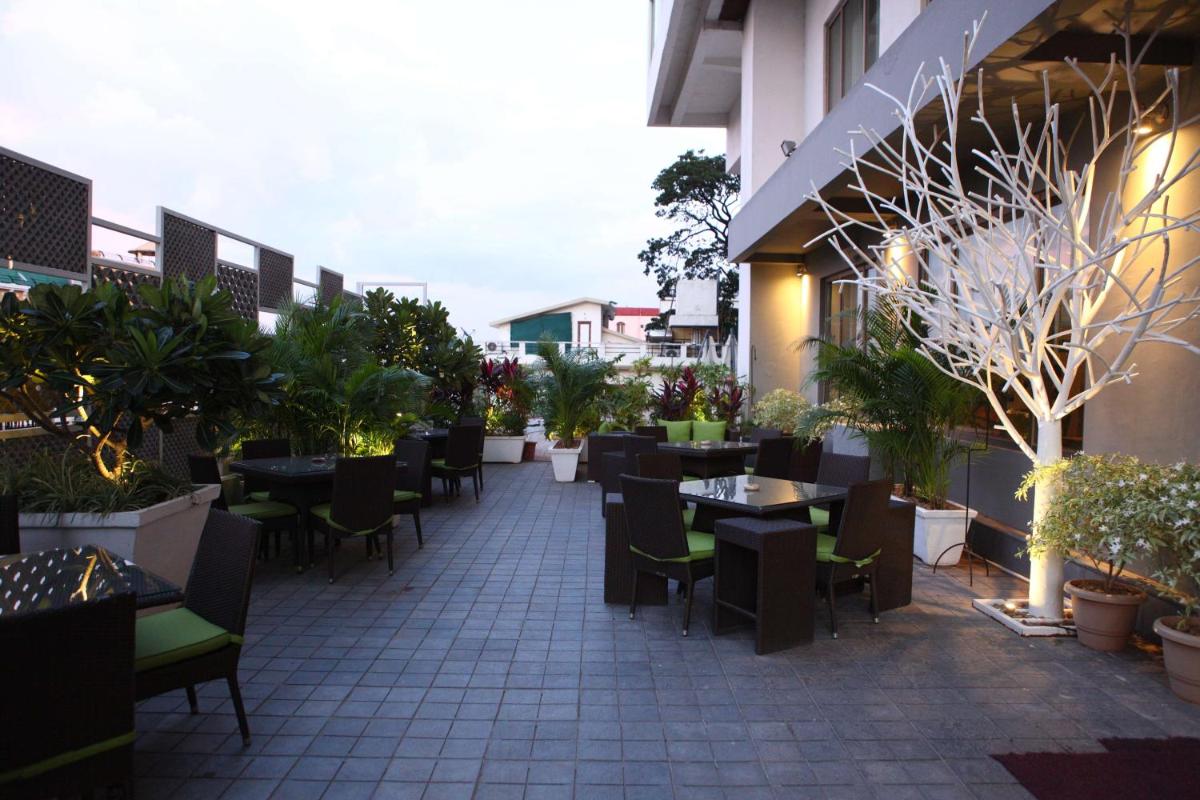 an outdoor patio with tables and chairs and plants at Radisson Blu Plaza Hotel Hyderabad Banjara Hills in Hyderabad an outdoor patio with tables and chairs and plants at Radisson Blu Plaza Hotel Hyderabad Banjara Hills in Hyderabad