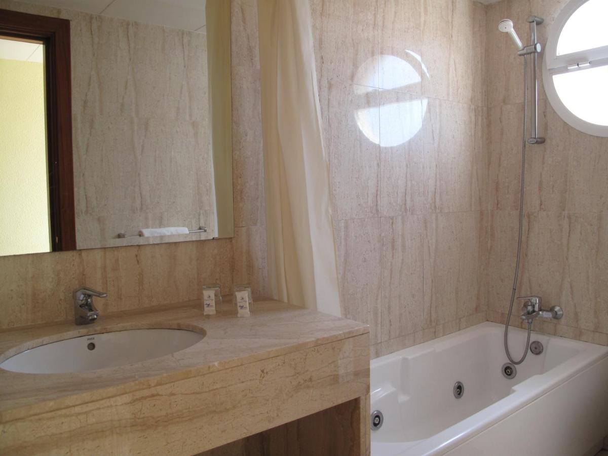 Un baño con lavabo, bañera y espejo. en Hotel Reymar, en Malgrat de Mar 45 fotos más