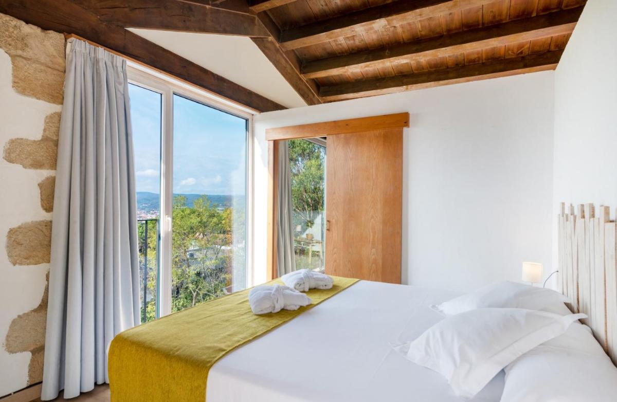 Un dormitorio con una cama y una ventana grande. en Mas Ses Vinyes - Adults Only, en Begur