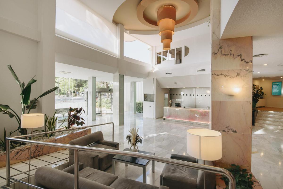 una sala de estar con un sofá y una mesa en Hotel Ivory Playa Sports & Spa, en Puerto de Alcudia