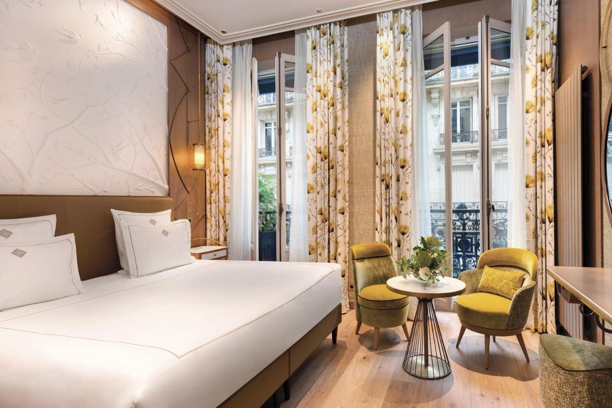 une chambre d'hôtel avec un lit, une table et des chaises dans l'établissement La Demeure Montaigne, à Paris 98 autres photos