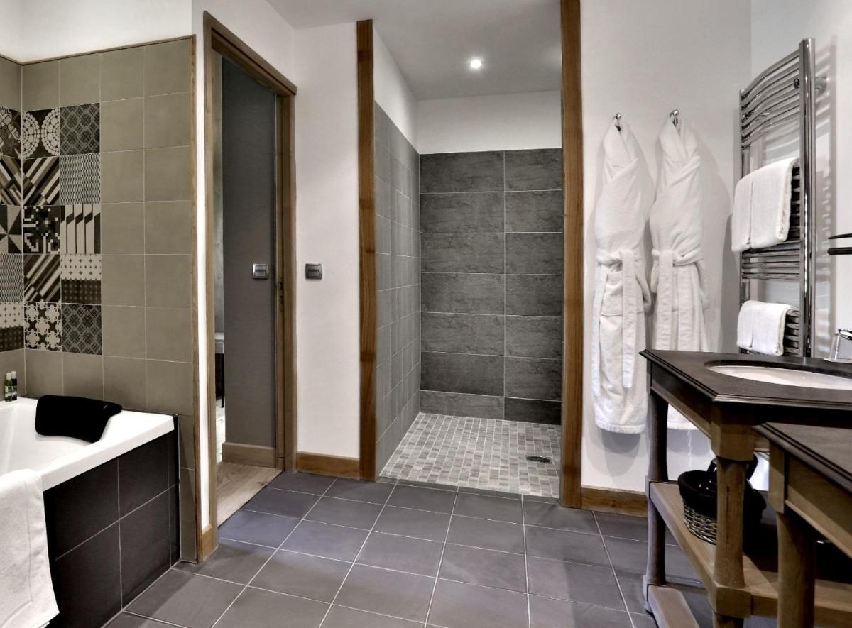 une salle de bain avec une douche, un lavabo et une baignoire dans l'établissement Les Glycines - Hôtel & Spa - Teritoria, à Les Eyzies-de-Tayac