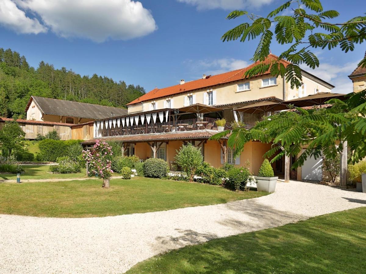 un grand bâtiment avec un jardin en face dans l'établissement Les Glycines - Hôtel & Spa - Teritoria, à Les Eyzies-de-Tayac