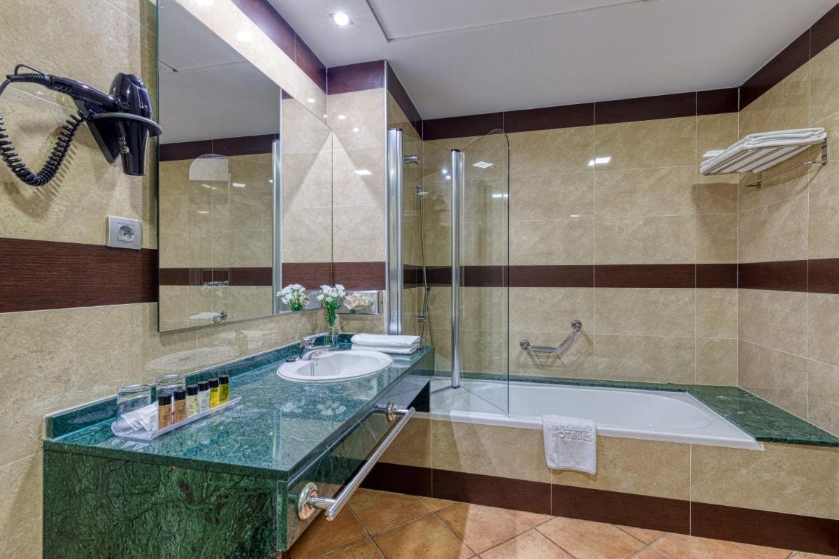 Un baño con una bañera grande y un lavabo. en Playazimbali, en Vera