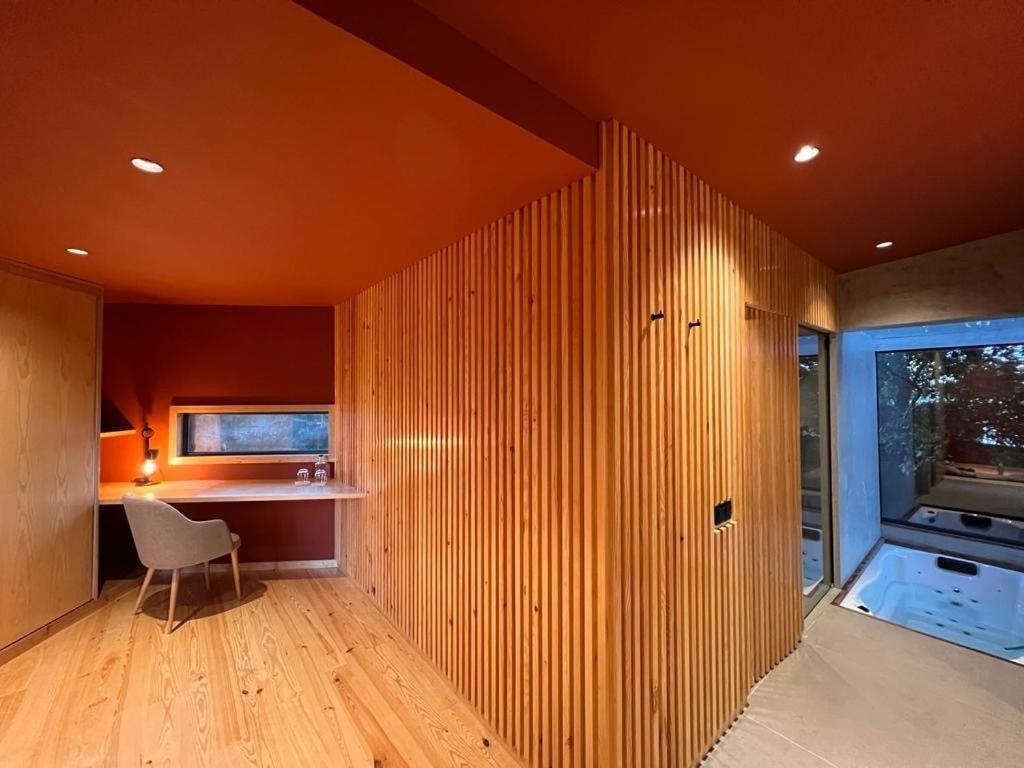 um quarto com uma parede de madeira com uma cadeira e uma secretária em Quinta do Pedregal Hotel & Spa em Vila Nova de Gaia