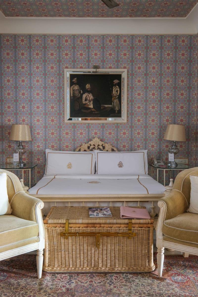 a living room with a large bed and two chairs at Rajmahal Palace RAAS in Jaipur